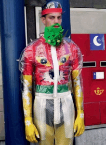 a man in a colorful costume stands in front of a mailbox with a letter c on it