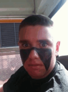 a man with black paint on his face is sitting in a car