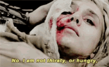 a woman with blood on her face is laying down and says " no i am not thirsty or hungry "