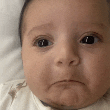 a close up of a baby 's face with the letter i in the eye