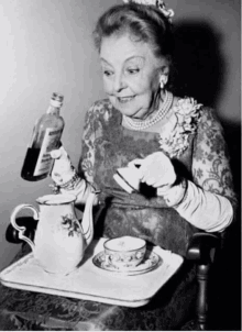 an older woman is pouring a drink into a cup