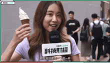 a woman holding an ice cream cone with a rode microphone behind her