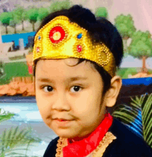 a little boy wearing a gold crown and a red shirt