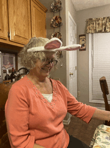 a woman wearing a bunny ear headband is smiling