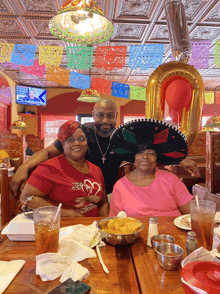 a man and two women are posing for a picture at a restaurant