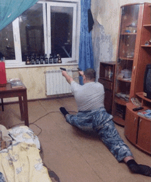 a man is holding a gun while doing a split in a living room