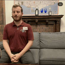 a man sitting on a couch with a name tag that says judy on it