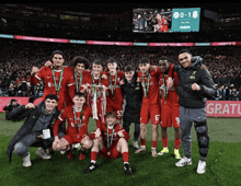 a group of soccer players posing for a photo with a trophy