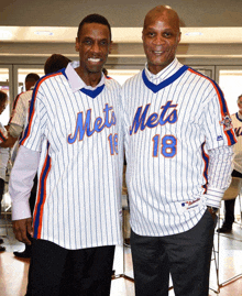 two men wearing mets jerseys are posing for a photo