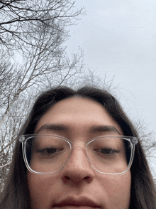 a woman wearing clear glasses looks at the camera