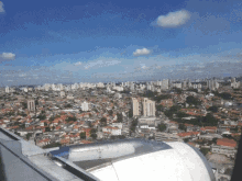 a view of a city from an airplane window with a few buildings including one that says ' hotel ' on it