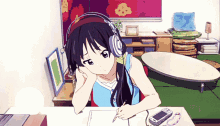 a girl wearing headphones is sitting at a desk writing on a piece of paper