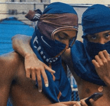 two men wearing masks are standing next to each other .