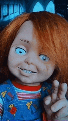 a chucky doll with red hair and blue eyes is waving