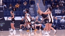 a group of female basketball players are playing basketball on a court .