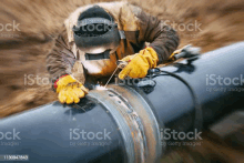 a man is welding a pipe with a welding torch .