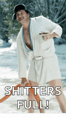 a man in a bathrobe is holding a hose with the words " shitters full " above him