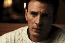 a close up of a man wearing a white sweater .