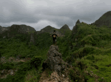 a person standing on top of a mountain wearing a shirt that says ' i love you ' on it