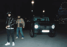 two men are standing in front of a mercedes with a license plate that says aa - aa