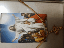 a picture of jesus surrounded by people is on a gold chain