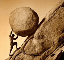 a man is pushing a large rock up a mountain