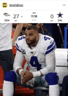 a cowboys player sits on the bench with the score of 27 to 0