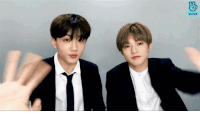 two men in suits and ties are waving their hands in front of a vlive screen