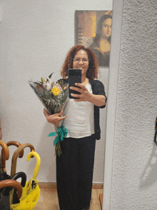 a woman taking a selfie with a bouquet of flowers in front of a mona lisa painting