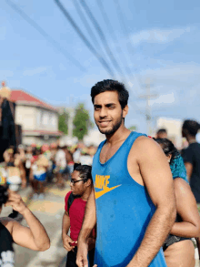 a man wearing a blue nike tank top