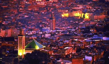 an aerial view of a city at night with buildings lit up