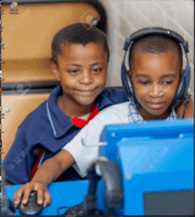 two boys wearing headphones are looking at a computer monitor