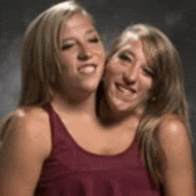 two women with two heads are posing for a picture together .