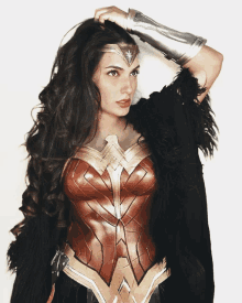 a woman in a wonder woman costume has her hand on her hair