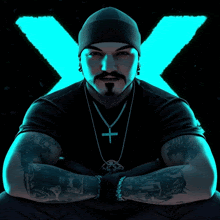 a man wearing a black shirt and a cross necklace with an x in the background