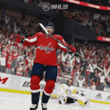 a hockey player for the capitals is holding a hockey stick in front of a crowd