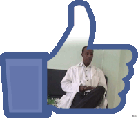 a man in a lab coat sits on a couch in front of a facebook thumbs up icon