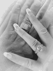 a black and white photo of a woman 's hand with a ring on it