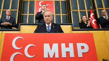 a man stands at a podium behind a sign that says cc mhp