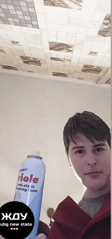 a young man is holding a can of viole anti-static foam