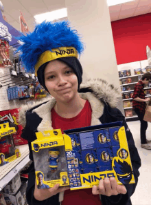 a boy wearing a ninja headband is holding a box of ninja action figures