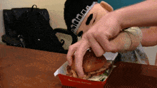 a person is eating a hamburger from a box that says real chicken real taste