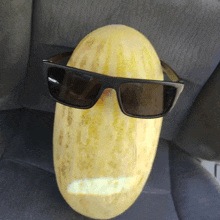 a melon wearing sunglasses has a smiley face on it