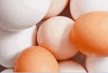 a pile of white and brown eggs are stacked on top of each other .