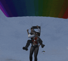 a man is carrying a woman on his back in a rainbow colored parachute