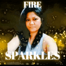 a woman is standing in front of a gold background with the words `` fire sparkles '' written on it .