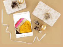 a tablet with a picture of a purse on the screen surrounded by christmas decorations