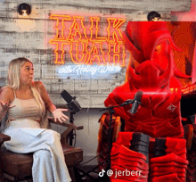 a woman sitting in front of a neon sign that says talk trash