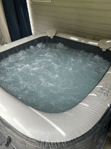 a hot tub is filled with blue water and has a warning label on the side