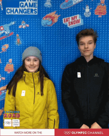 a boy and a girl are posing for a photo in front of a wall that says the game changers